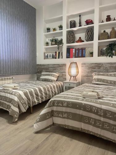 ein Schlafzimmer mit 2 Betten und Regalen mit Pflanzen in der Unterkunft Encanto cuenca puerta al silencio in Cuenca