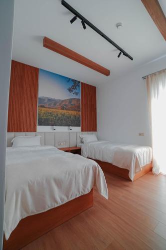 a bedroom with two beds and a large window at Mikheili's Marani Boutique Hotel in Kvareli