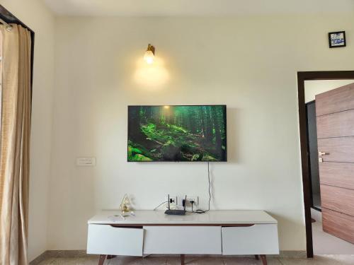 a room with a white desk with a picture on the wall at Ultra Luxe 2BHK Candolim Service Apartment with River and Mangrove Views in Candolim