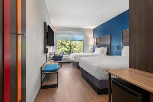 a hotel room with two beds and a desk at Tru By Hilton Flagstaff in Flagstaff