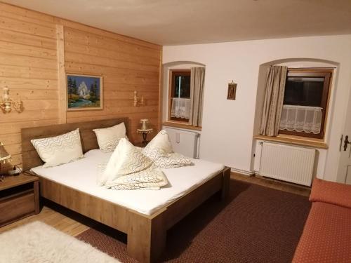 a bedroom with a bed with white sheets and pillows at Hause Alpina in Bichlbach