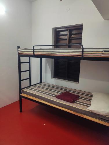 two bunk beds in a room with a red floor at Cuba beach villa in Alleppey