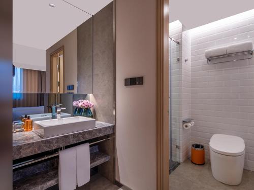 a bathroom with a sink and a toilet at Orange Hotel Beijing South Railway Station South Square in Beijing