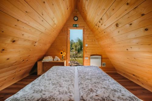 a bedroom with a large bed in a wooden room at Glamping Bizjak in Preddvor