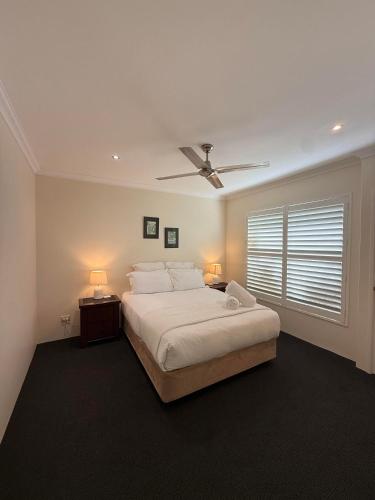 a bedroom with a bed and a ceiling fan at Busselton on the Beach in Busselton