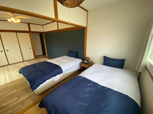 ein Schlafzimmer mit zwei Betten in einem Zimmer in der Unterkunft やどかり852 in Manazuru