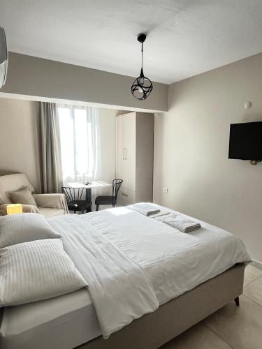 a bedroom with a large white bed and a table at Daily-Weekly-Monthly in Kötekli Center 