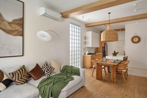 a living room with a couch and a table at Onyx Villas by TropicLook in Nai Harn Beach