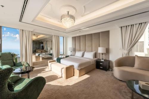 a hotel room with a bed and a couch and chairs at FAM Living- Luxe Penthouse in JBR Marina - Panaromic Sea View in Dubai