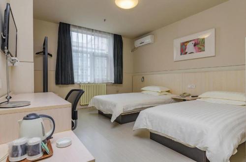 een ziekenhuiskamer met 2 bedden en een raam bij Jinjiang Inn Tai'an Taishan Railway Station in Tai'an