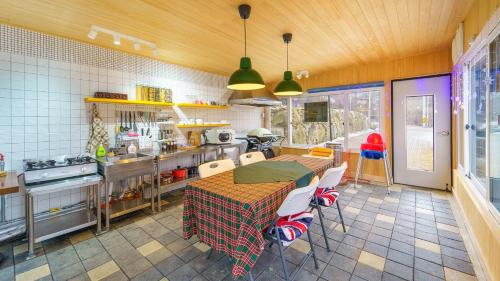Una cocina con una mesa y sillas en una cocina. en Yangpyeong The On Private Kids Pension, en Yangpyeong