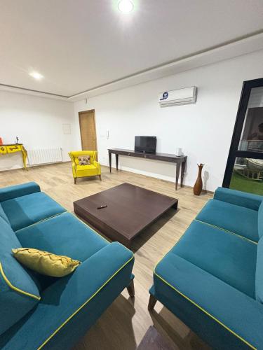 ein Wohnzimmer mit blauen Sofas und einem Klavier in der Unterkunft Résidence Jade in Sousse