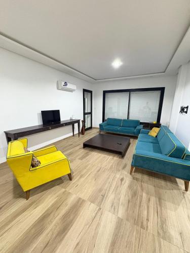 ein Wohnzimmer mit blauen und gelben Sofas und einem Fernseher in der Unterkunft Résidence Jade in Sousse