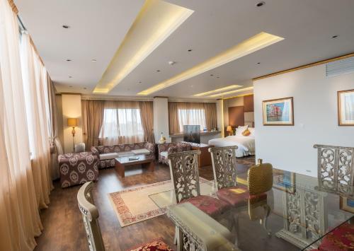a hotel room with a bed and a living room at Luxus Grand Hotel in Lahore
