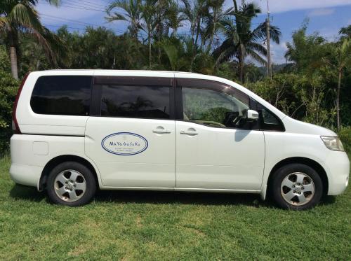 a small white van parked in the grass at Mayagusuku Resort in Iriomote