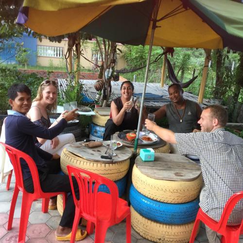 a group of people sitting around a table under an umbrella at Bunyong Homestay in Siem Reap