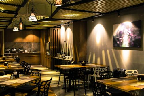 een restaurant met houten tafels en stoelen in een kamer bij Point Boutique Hotel in Phnom Penh