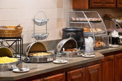 a kitchen with several pans of food on a counter at Hawthorn Suites by Wyndham Napa Valley in Napa
