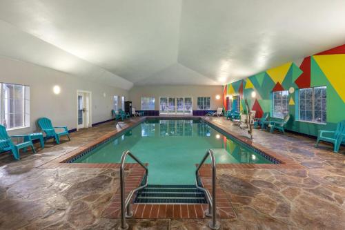 a swimming pool in a room with chairs and tables at La Quinta by Wyndham Oklahoma City - Moore in Moore