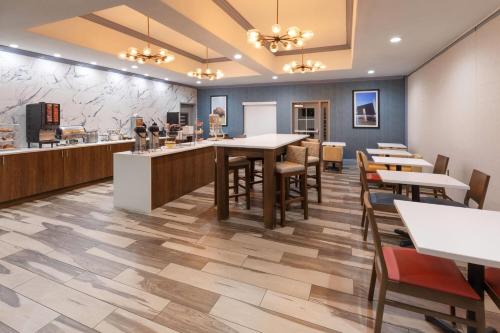 a restaurant with tables and chairs and a counter at La Quinta by Wyndham Oklahoma City - Moore in Moore