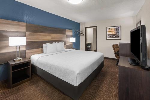 a hotel room with a bed and a flat screen tv at Baymont by Wyndham Downtown Detroit in Detroit