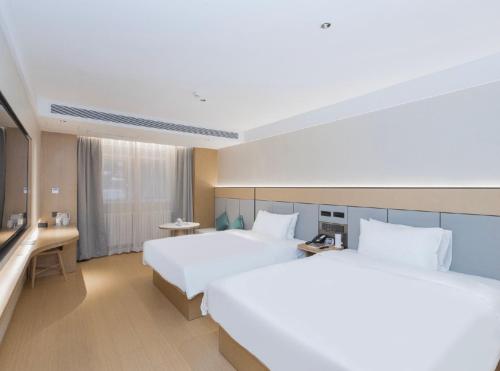 een hotelkamer met twee bedden en een bureau bij JI Hotel Beijing Xizhimen in Beijing
