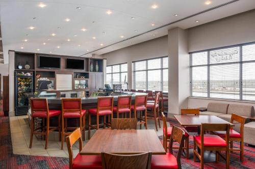 a restaurant with tables and chairs and a bar at Lakeview Signature, Trademark Collection by Wyndham in Winnipeg
