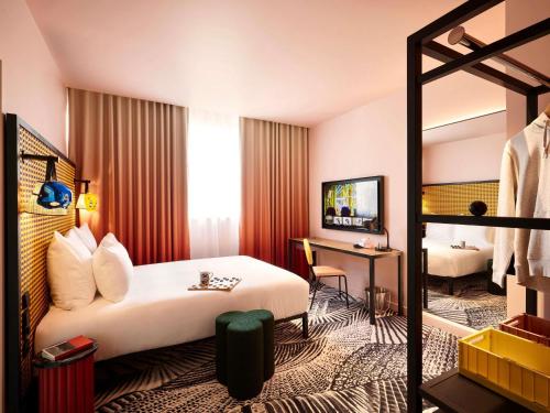 een hotelkamer met een bed en een bureau bij Mama Shelter Dijon in Dijon