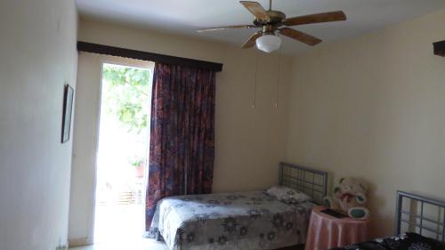 a bedroom with a bed and a ceiling fan at Kalampakas Guesthouse in Larnaka