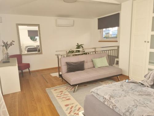 una sala de estar con un sofá y una cama en Villa Piccola, en Villach
