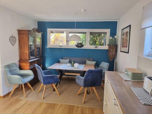 Un comedor con una mesa y sillas azules. en Villa Piccola, en Villach