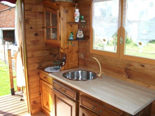 a kitchen with a sink and a window at Les Roulottes des Songes de l'Authie in Boufflers