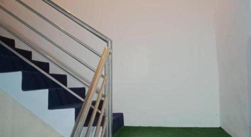 a staircase in a room with green flooring at OYO HOME 90671 Dd Rest House in Tawau