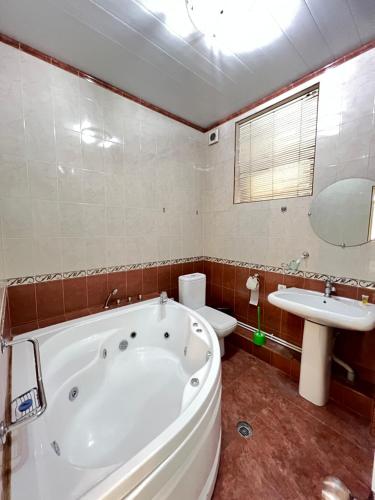 a bathroom with a tub and a toilet and a sink at The green regency in Toshkent-Passajir Bekati