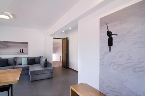 a living room with a wall mural of a woman dancing at Seametry Apartments in Souda