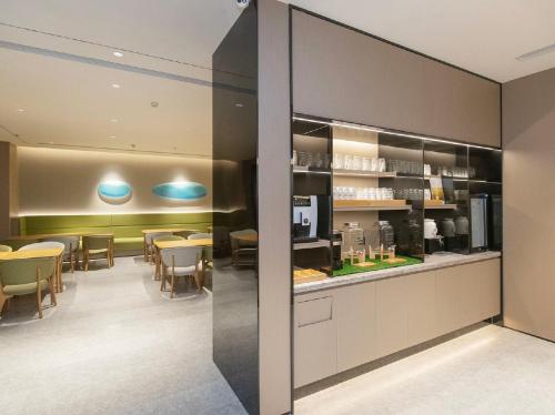 een restaurant met tafels en stoelen en een toonbank bij JI Hotel Beijing Xizhimen in Beijing