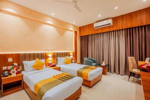 a hotel room with two beds and a desk at Amity's Courtyard in Jāmb