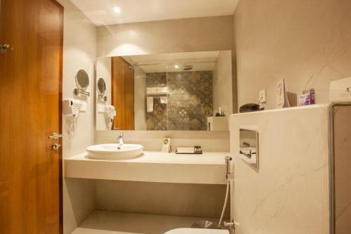a bathroom with a sink and a toilet and a mirror at Amity's Courtyard in Jāmb
