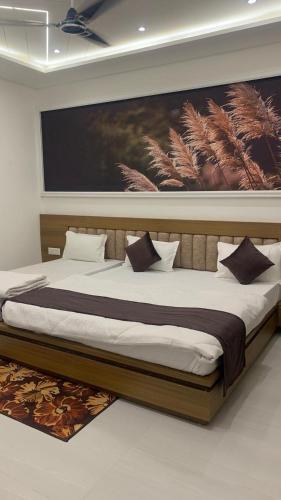 a bedroom with a large bed with a painting on the wall at Shreeramyadham vrindavan in Vrindāvan