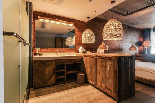 a kitchen with wooden cabinets and a sink and a tub at Tropical Hideaway in Seogwipo