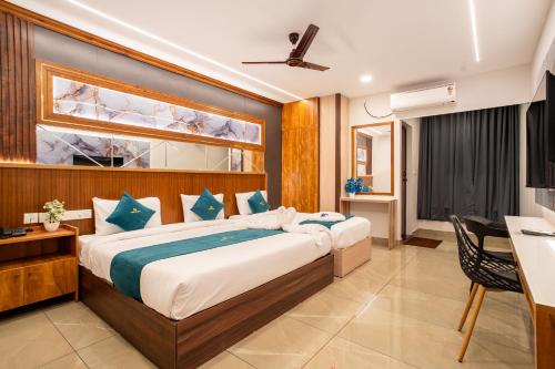 a bedroom with a large bed and a desk at Daan Luxe Inn in Trivandrum