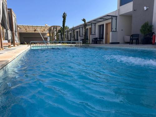 a swimming pool with blue water in front of a building at The D9 Luxury Suites - Hurghada in Hurghada