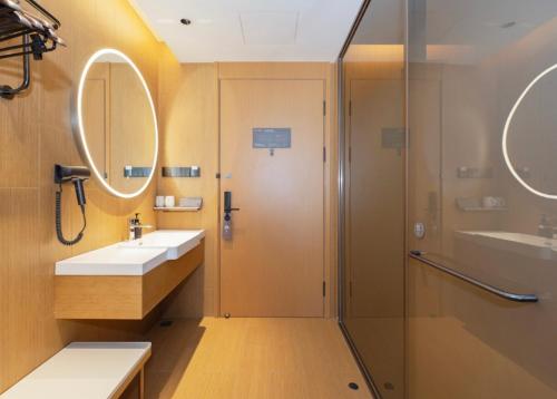 a bathroom with a shower and a sink at JI Hotel Shanghai Baoyang Road Subway Station in Baoshan