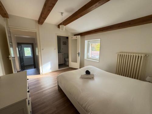 a bedroom with a white bed and a window at L'escapade Beaujolaise in La Chapelle-de-Guinchay