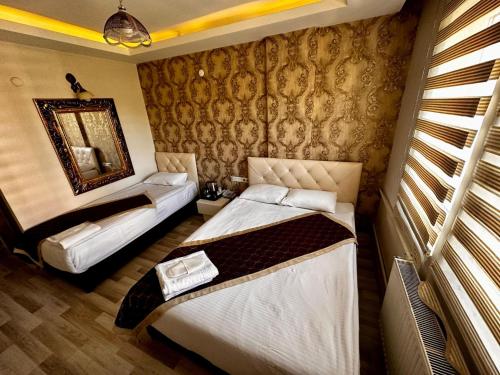 a hotel room with two beds and a mirror at Hotel seven park in Nevsehir