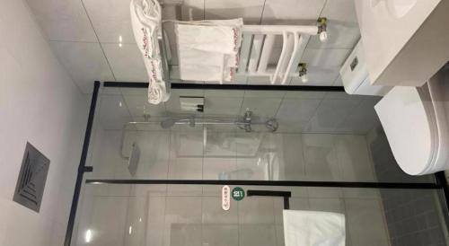 een badkamer met een glazen douche met toilet bij Shell Zhengzhou North Third Ring University Science and Technology Park Hotel in Laoyachen