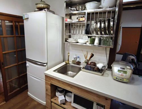 a kitchen with a sink and a white refrigerator at Yokosukanominpaku Iriyamazu & Nariyamazu - Vacation STAY 18954 in Yokosuka