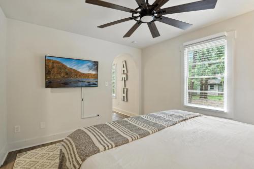 a bedroom with a bed and a ceiling fan at Athenian Haus with Grill in Athens