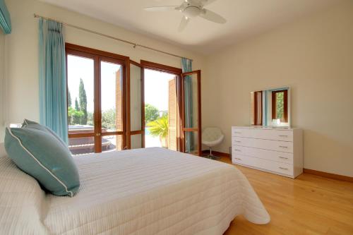 a bedroom with a white bed and a window at Villa UNIDERA in Kouklia
