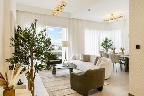 a living room with a white couch and a table at FAM Living - 3 bedroom and Maids Room Retreat Overlooking Dubai Canal in Dubai